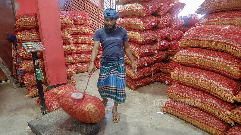 ঢাকার ফরাশগঞ্জে পেঁয়াজের আড়তে শ্রমিকদের ব্যস্ততা।  ছবি: আব্দুল্লাহ আল মমীন
