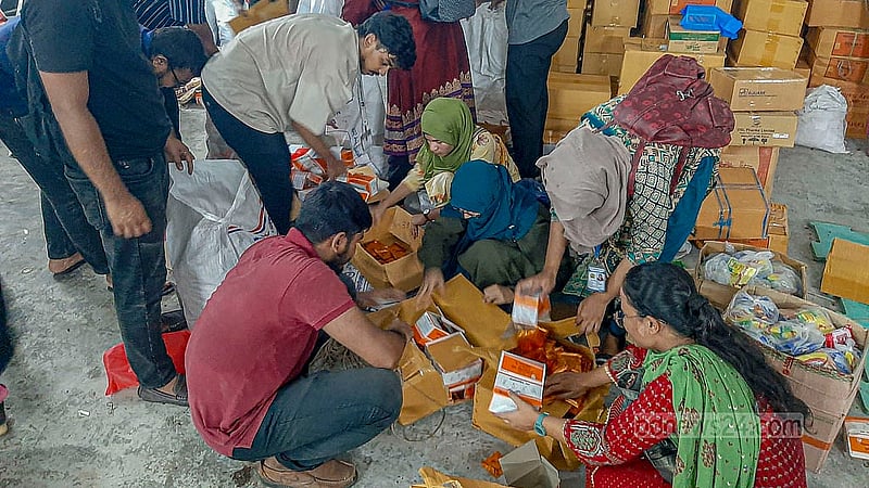 ঢাকা বিশ্ববিদ্যালয়ের শারীরিক শিক্ষাকেন্দ্রের ভেতরে সোমবার দুপুরে ত্রাণ সংগ্রহে ব্যস্ত স্বেচ্ছাসেবীরা।