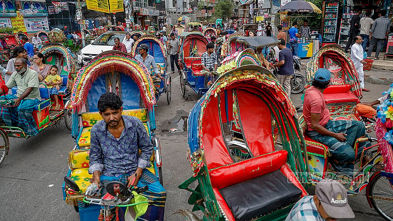 রাজধানীর ধানমন্ডির জিগাতলা মোড়ে হাজারীবাগ যাওয়ার রাস্তার দুই পাশে যাত্রী নেওয়ার অপেক্ষায় ব্যাটারি রিকশার চালকরা। ছবি: মাহমুদ জামান অভি