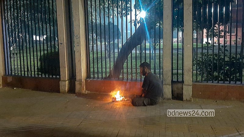 তীব্র ঠান্ডার মধ্যে জাতীয় প্রেস ক্লাবের সামনে ফুটপাতে আগুন জ্বালিয়ে শীত নিবারণের চেষ্টা। ছবি: আব্দুল্লাহ আল মমীন