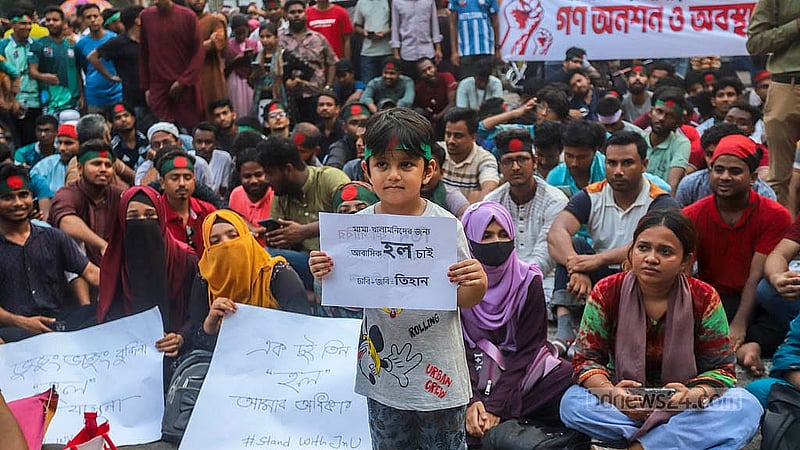 কাকরাইল মসজিদ মোড়ে শুক্রবার জগন্নাথ বিশ্ববিদ্যালয়ের আন্দোলনরত শিক্ষার্থীদের সঙ্গে প্ল্যাকার্ড হাতে শিশু। ছবি: আব্দুল্লাহ আল মমীন