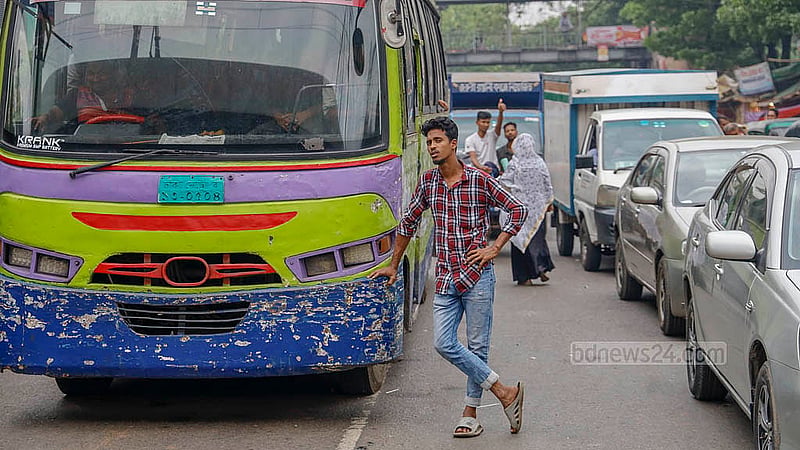 দাবি আদায়ে আন্দোলন চলছে, তাই তীব্র যানজট। বাসের বাইরে দাঁড়িয়ে অপেক্ষায় হেলপার। ছবি: মাহমুদ জামান অভি
