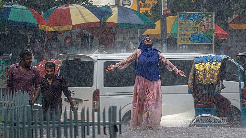 বৃহস্পতিবার বিকেলে ঢাকা বিশ্ববিদ্যালয় এলাকায় বৃষ্টি উপভোগ করছেন এক নারী।