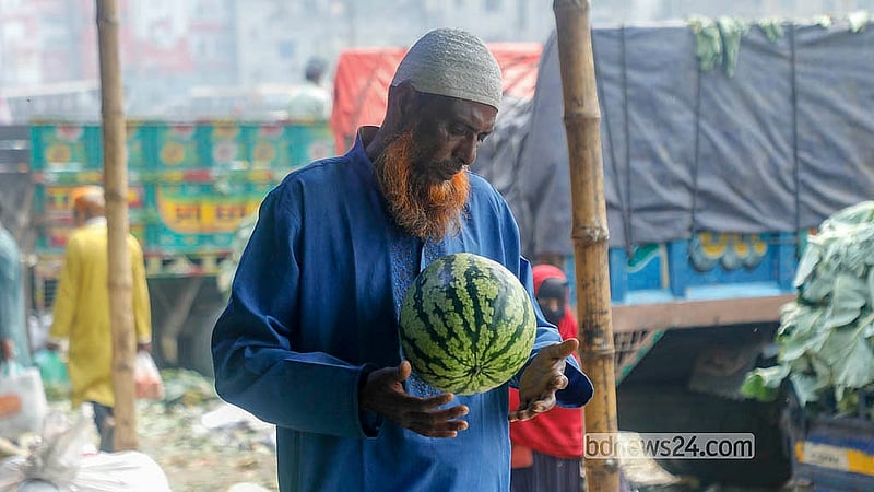 রাজধানীর যাত্রাবাড়ী আড়তে তরমুজ দেখছেন এক ক্রেতা। আকার ভেদে প্রতিকেজি বিক্রি হচ্ছে ৫০ থেকে ৭০ টাকায়। ছবি: আব্দুল্লাহ আল মমীন