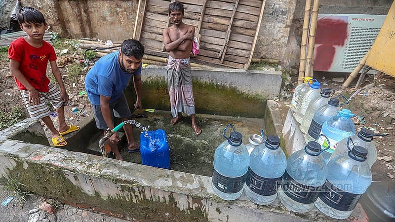 লালবাগের আমলিগোলা এলাকায় সড়কের পাশে ওয়াসার কল থেকে খাবার পানি সংগ্রহ করেন স্থানীয়রা। ছবি: আব্দুল্লাহ আল মমীন