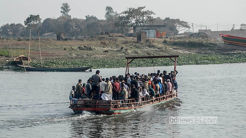 স্থানীয়ভাবে তৈরি ফেরি দিয়ে দক্ষিণ কেরাণীগঞ্জের মোল্লাবাজার এলাকায় ধলেশ্বরী শাখা নদী পার হচ্ছে মানুষ