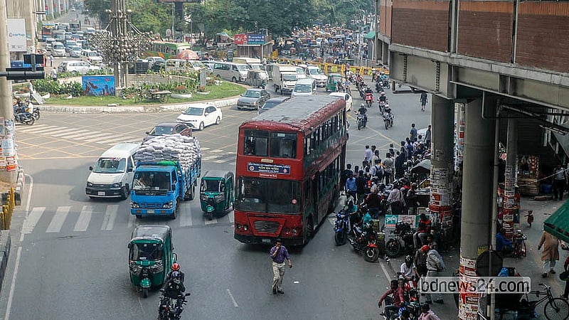 এআই ক্যামেরা সম্পর্কে অবগত নয় যানবাহন চালকদের অনেকেই। রাজধানীর কারওয়ানবাজার মোড়ে বাস থামিয়ে যাত্রী তুলছেন চালক।  ছবি: আব্দুল্লাহ আল মমীন