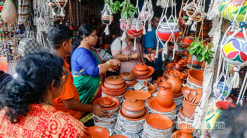 ঢাকার অনেক মানুষ বৈশাখ বরণের পণ্য কেনেন ঢাকা বিশ্ববিদ্যালয়ের দোয়েল চত্বরের কারুশিল্পের দোকানগুলো থেকে