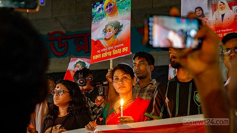 ধর্ষণ ও নারী নির্যাতনের প্রতিবাদে বৃহস্পতিবার রাতে রাজু ভাস্কর্যের সামনে মোমবাতি হাতে এক নারী। ছবি: মাহমুদ জামান অভি
