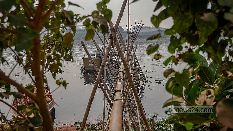 বালু তুলে আনার পাইপ রাখা হয়েছে সারি সারি বাঁশের ওপর। এসব পাইপের এক মাথা বালুর ড্রেজারের সঙ্গে যুক্ত, অপর অংশ দিয়ে বালু ফেলা হয় নদীর তীরে