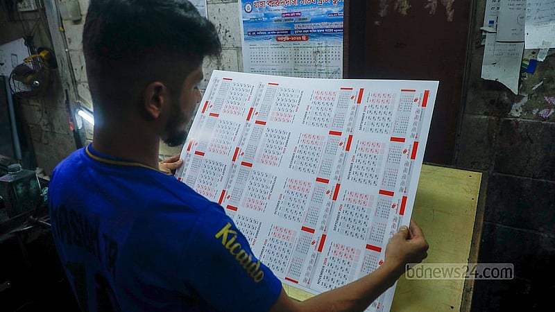 ক্যালেন্ডারের পাতাগুলো ঠিকভাবে ছাপা হয়েছে কিনা তা দেখছেন এক কর্মী। ফকিরাপুলের ছাপাখানাগুলোতে চলছে ক্যালেন্ডার ছাপার কাজে।  ছবি: আব্দুল্লাহ আল মমীন