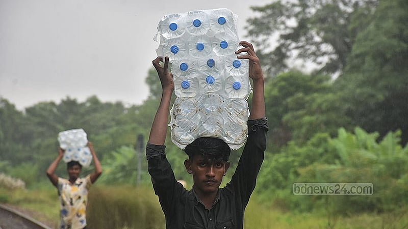 ফেনী সদর উপজেলার ফাজিলপুরের বন্যার্তদের জন্য খাবার পানি নিয়ে যাচ্ছেন স্বেচ্ছাসেবীরা। ছবি: সুমন বাবু