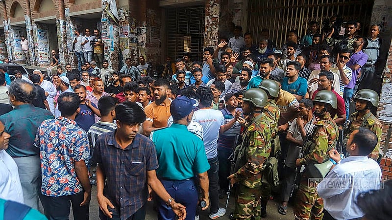 সাবেক বন ও পরিবেশমন্ত্রী সাবের হোসেন চৌধুরীকে সোমবার আদালতে তোলার খবর পেয়ে জড়ো হওয়া বিক্ষোভকারীদের বোঝানোর চেষ্টায় সেনা সদস্যরা। ছবি: আব্দুল্লাহ আল মমীন
