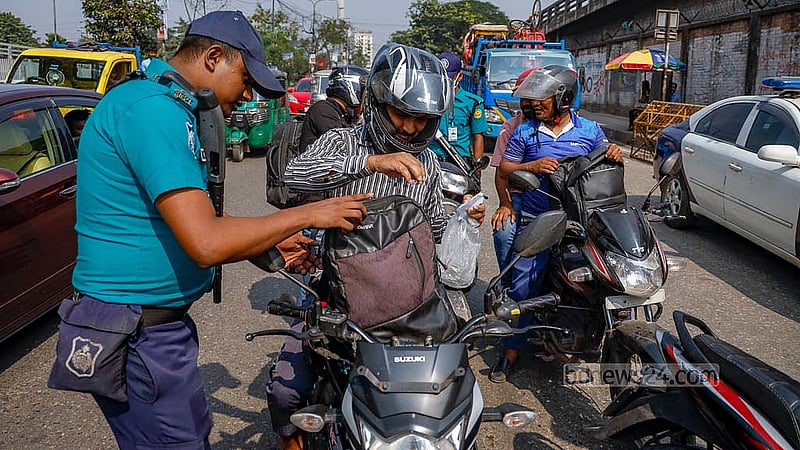 রামপুরা টিভি সেন্টারের সামনে বুধবার নিরাপত্তা জোরদারের অংশ হিসেবে মোটরসাইকেল চালকের ব্যাগ তল্লাশি করেন পুলিশ সদস্যরা