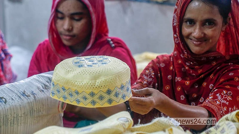 ঢাকার কামরাঙ্গীরচরের একটি কারখানায় টুপি তৈরির পর তা দেখাচ্ছেন এক নারী কারিগর