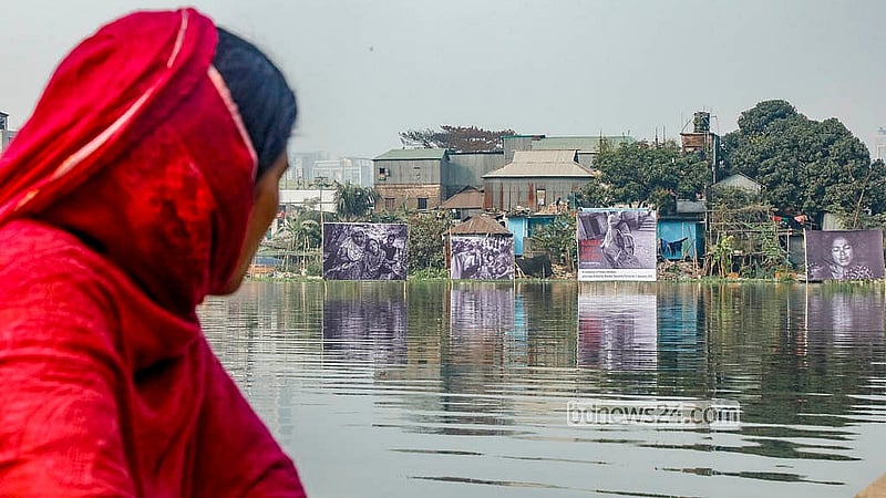 ফেলানী দিবস উপলক্ষে সীমান্ত হত্যার প্রতিবাদ জানিয়ে ঢাকার কড়াইল লেকে আয়োজিত আলোকচিত্রী পারভেজ আহমদ রনির প্রদর্শনীর ছবি নৌকায় বসে দেখছেন এক নারী।  ছবি:আব্দুল্লাহ আল মমীন