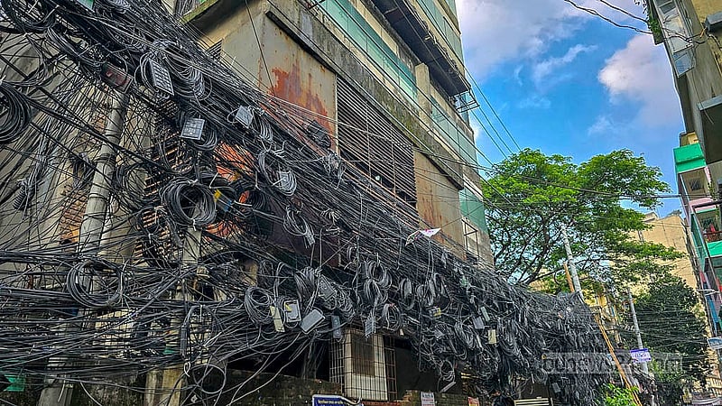 রাজধানীর মহাখালী এলাকায় বিদ্যুতের খুঁটি ও সড়কের পাশজুড়ে ছড়িয়ে আছে ইন্টারনেট ও স্যাটেলাইট কেবলের জঞ্জাল