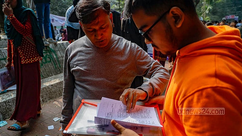 ঢাকা বিশ্ববিদ্যালয়ে শনিবার ভর্তি পরীক্ষা শেষে অভিভাবককে প্রশ্ন দেখাচ্ছেন এক শিক্ষার্থী। ছবি: মাহমুদ জামান অভি