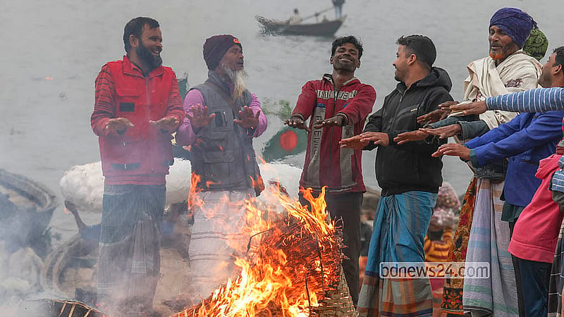 ঢাকার সদরঘাট এলাকায় বুড়িগঙ্গা নদীর পাড়ে শীতে উষ্ণতা পেতে কাঠখড়িতে আগুন জ্বালিয়েছে কিছু মানুষ
