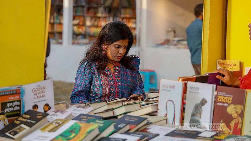 বইমেলার দ্বিতীয় দিন শুক্রবার সোহরাওয়ার্দী উদ্যানে বই দেখছেন এক তরুণী
