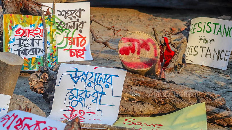 পান্থকুঞ্জ পার্কে নির্মাণাধীন এলিভেটেড এক্সপ্রেসওয়ের যন্ত্রাংশ ঘিরে রাখা হয়েছে প্ল্যাকার্ড। বিভিন্ন সংগঠনের আন্দোলনের মুখে সেখানে বন্ধ রয়েছে এক্সপ্রেসওয়ের নির্মাণ কাজ। ছবি: আব্দুল্লাহ আল মমীন