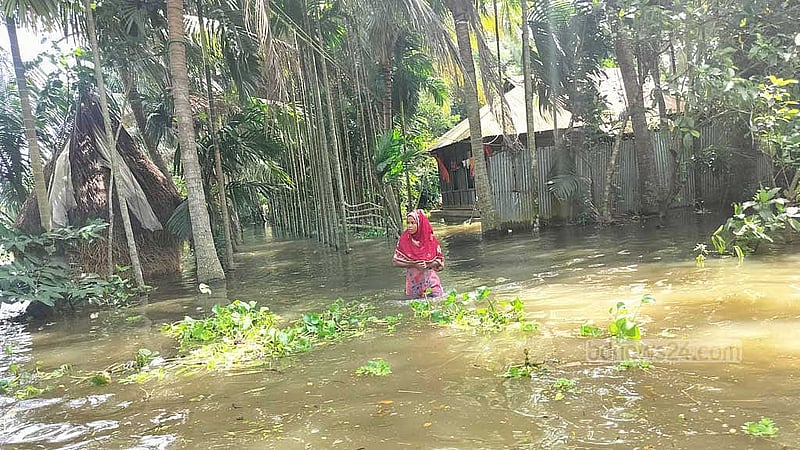 পার্বতীনগর ইউনিয়নের উত্তর মকরধ্বজপুর গ্রামে এক জায়গা থেকে অন্য জায়গায় যেতে এভাবেই পানি ভাঙতে হচ্ছে। শনিবার তোলা।