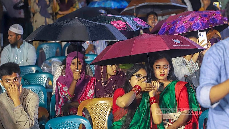 রাজধানীর কেন্দ্রীয় শহীদ মিনার প্রাঙ্গণে সোমবার বৃষ্টির মধ্যে ছাতা মাথায় নিয়ে ‘জুলাই গণঅভ্যুত্থান স্মরণ-২০২৫’ অনুষ্ঠান দেখেন অনেক মানুষ। ছবি: আব্দুল্লাহ আল মমীন