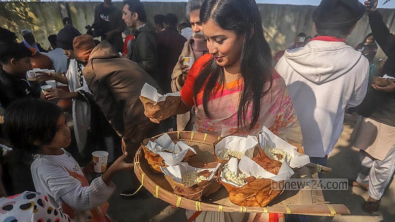 রসের মেলায় আসা সকলকে খেজুরের রস, গুড়-মুড়ি-খই আপ্যায়ন করা হয়। শুকনো পাতায় তৈরি বাটিতে গুড় ও খই-মুড়ির স্বাদ নেই দর্শনার্থীদের অনেকেই। ছবি: আব্দুল্লাহ আল মমীন