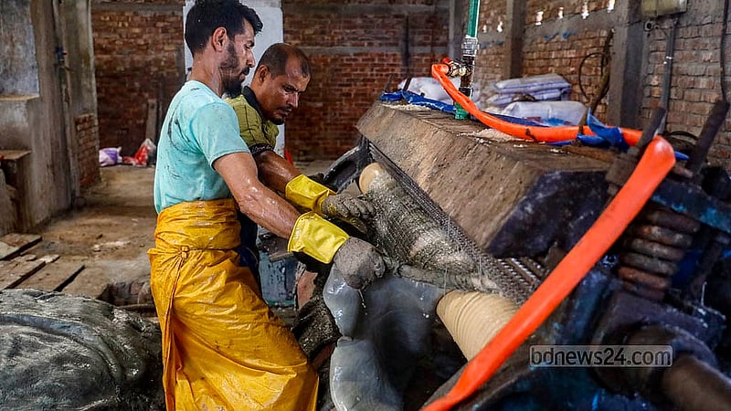 সাভার ট্যানারিতে কোরবানির ঈদের পশুর চামড়া সংরক্ষণের প্রথম ধাপ শেষে মেশিনের সাহায্যে চামড়া থেকে নরম হয়ে যাওয়া পশম আলাদার কাজ করছেন দুই শ্রমিক। ছবি: মাহমুদ জামান অভি