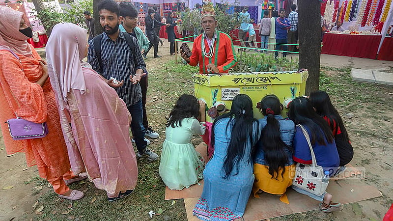 ঢাকা বিশ্ববিদ্যালয়ের চারুকলায় জয়নুল উৎসবে বায়োস্কোপ নিয়ে হাজির হয়েছেন এক ব্যক্তি; গ্রামীণ মেলার আমেজে বায়োস্কোপে চোখ রেখে ছোটবেলার স্মৃতি স্মরণ করলেন দর্শনার্থীরা। ছবি: আব্দুল্লাহ আল মমীন