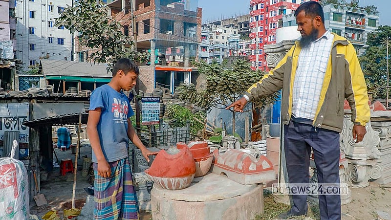 লাকড়ির চুলা দেখছেন এক ক্রেতা। নারায়ণগঞ্জের চিটাগং রোড এলাকার একটি কারখানায় এসব চুলা তৈরি করা হচ্ছে। আগে তেমন বিক্রি না হলেও দিনে এখন ২০/২৫টি চুলা বিক্রি করছেন কারিগররা। ছবি: আব্দুল্লাহ আল মমীন