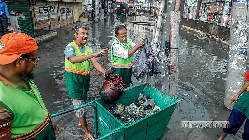 সোমবার দুপুরের বৃষ্টিতে যাত্রাবাড়ীর কুতুবখালী এলাকায়  জলজট তৈরি হলে আবর্জনা পরিষ্কার করেন সিটি করপোরেশনের কর্মীরা