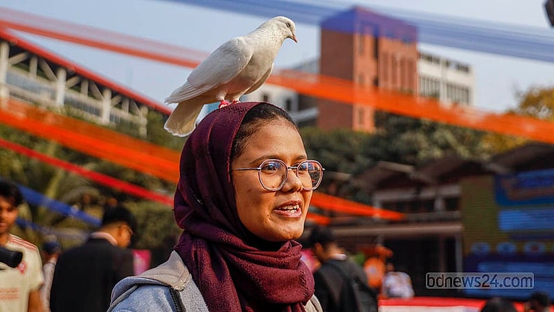 ঢাকা বিশ্ববিদ্যালয়ের শিক্ষার্থী সাগুফতা ইয়াসমিন জেরিন নারায়ণগঞ্জ থেকে নিয়ে এসেছেন তার পোষ্য কবুতর হাননাকে। পেট কার্নিভালে এসে জেরিনের মাথায় ঘুরে দেশি জাতের কবুতরটি। ছবি: মাহমুদ জামান অভি