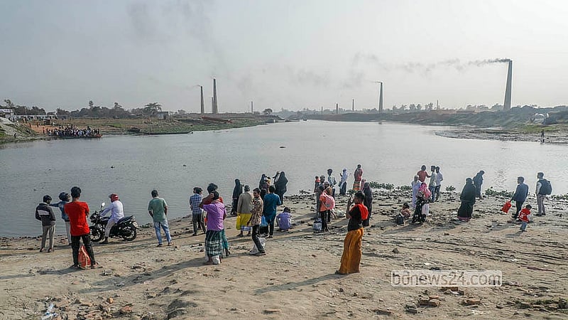 কেরাণীগঞ্জের মোল্লাবাজার এলাকায় ধলেশ্বরী শাখা নদী পার হওয়ার অপেক্ষায় মানুষ। সেতুর কাজ শেষ না হওয়ায় প্রতিদিন হাজারো মানুষ ঝুঁকি ফেরিতে নদী পার হচ্ছেন