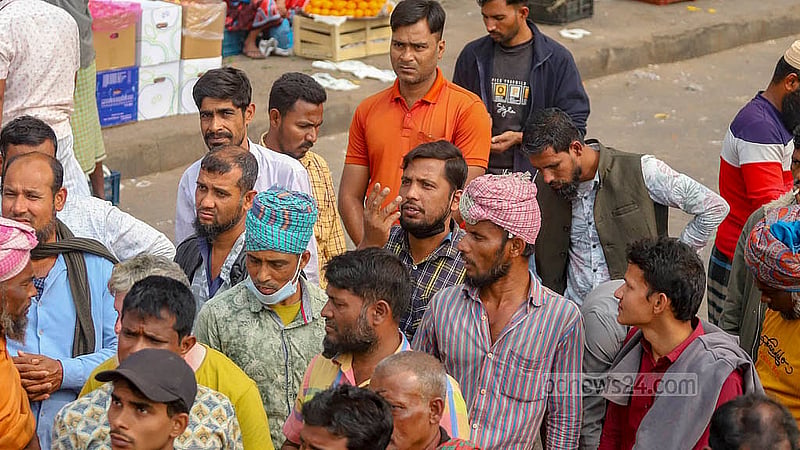 পুরান ঢাকার বাদামতলী ঘাটে কমলা কিনতে পাইকারকে হাতের ইশারায় দাম বলছেন এক খুচরা বিক্রেতা। ছবি: আব্দুল্লাহ আল মমীন
