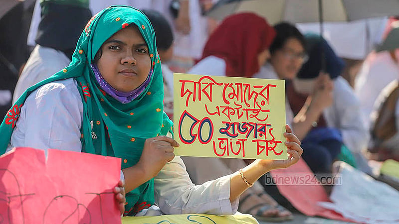রাজধানীর শাহবাগ মোড়ে রোববার ভাতা বাড়ানোর এক দফা দাবির প্ল্যাকার্ড হাতে ট্রেইনি চিকিৎসকরা। ছবি: আব্দুল্লাহ আল মমীন