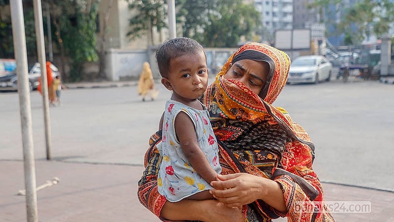 হামে আক্রান্ত শিশু আরাফকে নিয়ে হাঁটছে মা। ছয়দিন আগে শিশুটিকে ভর্তি করা হয়েছে মহাখালীর ডিএনসিসি ডেডিকেটেড কোভিড-১৯ হাসপাতালে। তাদের বাড়ি নোয়াখালীর রামগঞ্জ উপজেলায়। ছবি: আব্দুল্লাহ আল মমীন