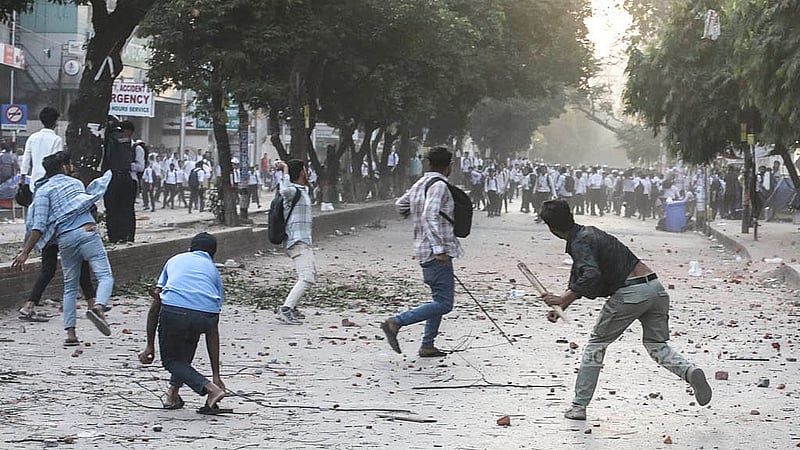 সায়েন্স ল্যাবরেটরি মোড়ে বুধবার লাঠিসোঁটা হাতে মারমুখি ঢাকা কলেজের শিক্ষার্থীরা। এসময় সিটি কলেজের শিক্ষাথীদের দিকে ঢিল ছুড়তে দেখা যায় তাদের।