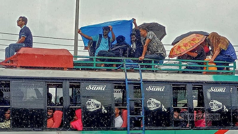পরিবারের সঙ্গে ঈদ উদযাপনে বৃহস্পতিবার বাসের ছাদে বৃষ্টিতে ভিজে ভিজে বাড়ি ফেরেন অনেকে। ছবি: মো. তোফাজ্জল হোসেন