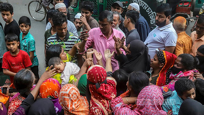 টিসিবির পণ্য পাওয়ার জন্য ক্রেতাদের হাতে সিরিয়াল নম্বর লিখে দিচ্ছেন একজন। সোমবার রাজধানীর মানিকনগর এলাকা থেকে তোলা। ছবি: আব্দুল্লাহ আল মমীন