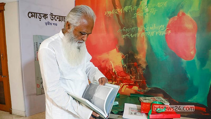 ‘রক্তরেখায় বাংলাদেশের’ তৃতীয় খণ্ডের মোড়ক উন্মোচন অনুষ্ঠানে বই হাতে মুক্তিযোদ্ধা কামরুল আমান।