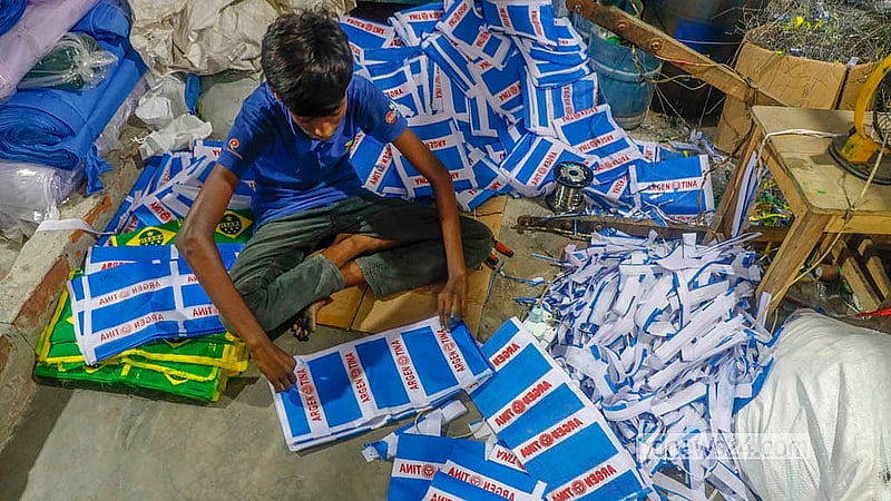 ঢাকার কদমতলীতে কাঠির সঙ্গে লাগানো ছোট ছোট একশটি পতাকার দাম পড়ে পাইকারিতে ২০০ থেকে ২৫০ টাকা