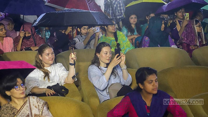 রাজধানীর কেন্দ্রীয় শহীদ মিনার প্রাঙ্গণে সোমবার বৃষ্টির মধ্যে ছাতা মাথায় নিয়ে ‘জুলাই গণঅভ্যুত্থান স্মরণ-২০২৫’ অনুষ্ঠান দেখেন অনেক মানুষ। ছবি: আব্দুল্লাহ আল মমীন