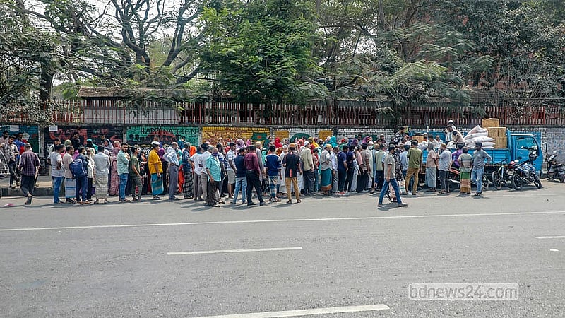 ঢাকার আগারগাঁও এলাকায় বৃহস্পতিবার দুপুরে রোদের মধ্যে টিসিবির পণ্য কিনতে লাইনে অপেক্ষায় থাকেন স্থানীয় বাসিন্দারা