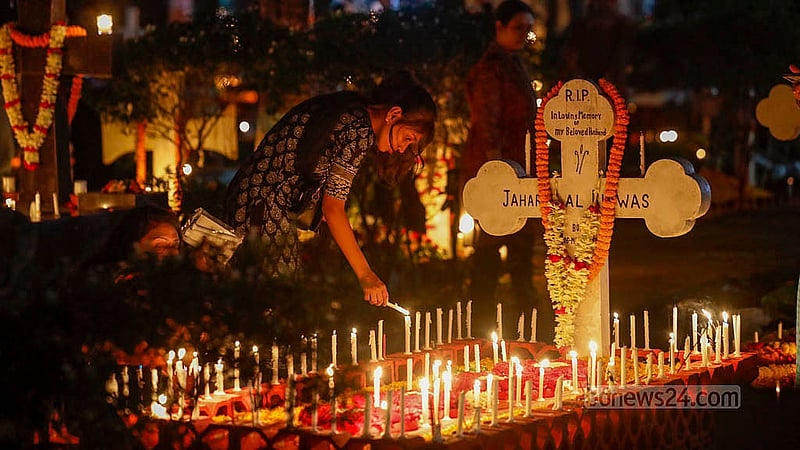 ‘অল সোলস ডেতে’ প্রয়াতদের আত্মার শান্তি কামনায় ঢাকার ওয়ারীতে খ্রিষ্টান সমাধি ক্ষেত্রে একটি সমাধিতে মোমবাতি প্রজ্জলনে এক তরুণী। ছবি: মাহমুদ জামান অভি