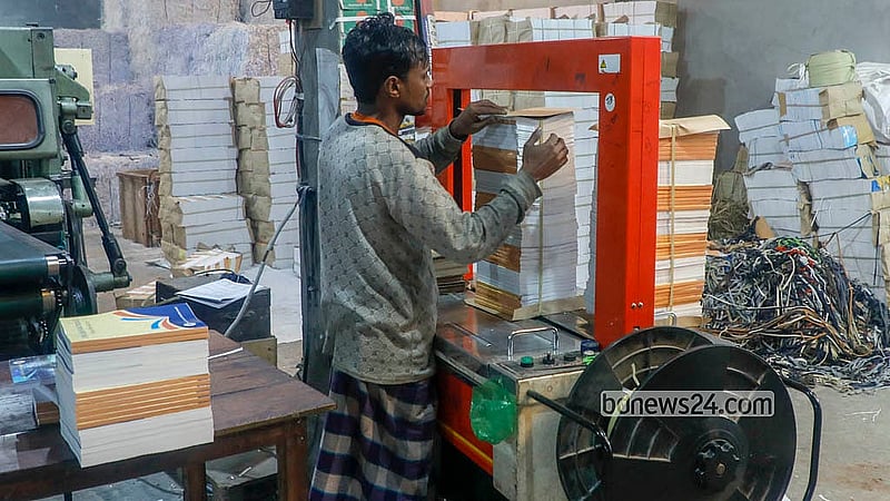 ঢাকার মাতুয়াইল এলাকায় একটি ছাপাখানায় পাঠ্যবই ছাপানোর কাজে ব্যস্ত সময় পার করছেন শ্রমিকরা