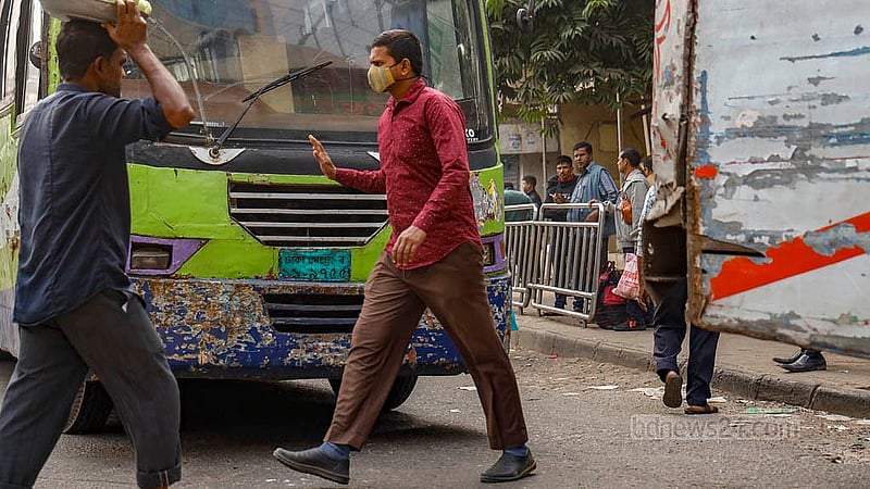 ঢাকার পল্টন এলাকায় সড়কে গাড়ি থামার ইশারা দিয়ে সড়ক পাড় হচ্ছেন এক ব্যক্তি। ছবি: মাহমুদ জামান অভি