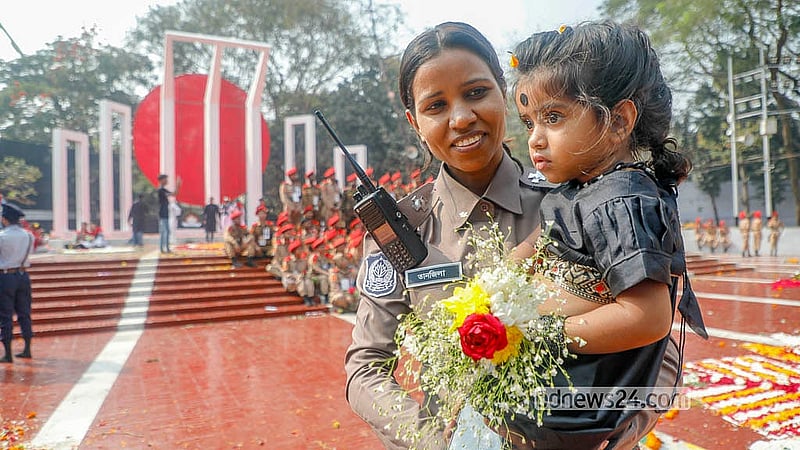 মা পুলিশ সদস্য, সন্তানকে নিয়ে এসেছেন শহীদ মিনার প্রাঙ্গণে। ছবি: আব্দুল্লাহ আল মমীন