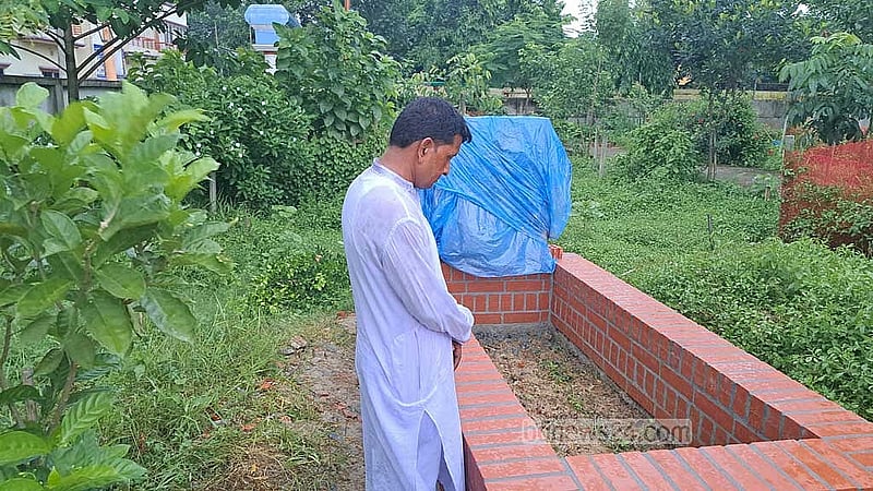 নাফিসার সমাধির সামনে দাঁড়িয়ে বাবা আবুল হোসেন। 