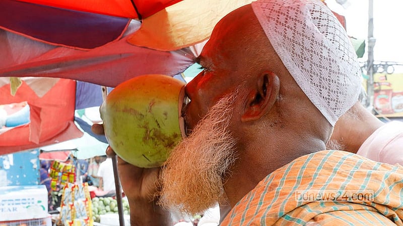 জ্যৈষ্ঠের দুপুরের গরমে তৃষ্ণা মেটাতে ডাবের দোকানে ভিড় করছেন পথচারীরা
